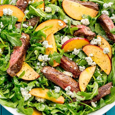 arugula salad topped with balsamic steak, peaches, and blue cheese