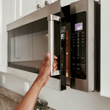 close up of woman opening microwave