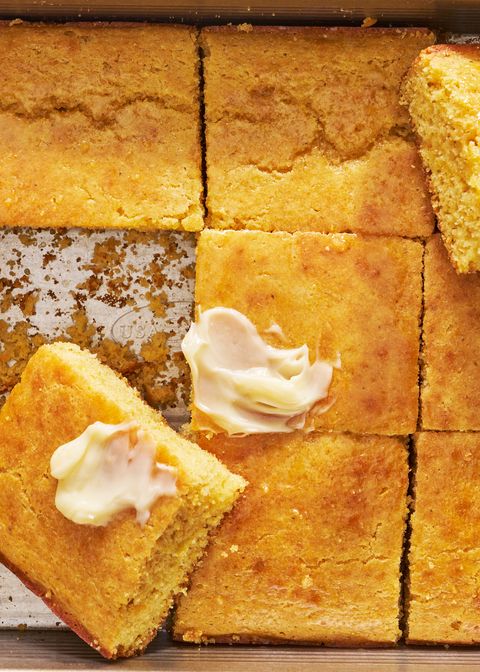 pan of homemade cornbread sliced into squares and topped with honey butter