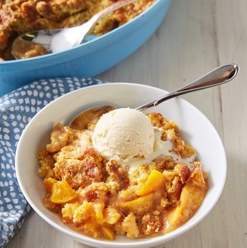 peach dump cake topped with vanilla ice cream in a white bowl