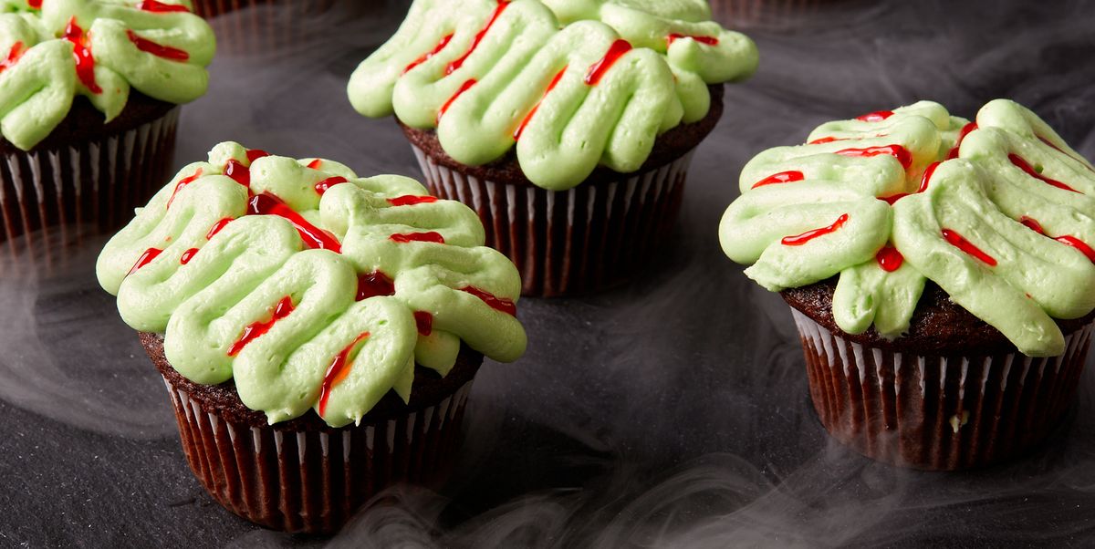 chocolate cupcakes decorated with green frosting and red gel food coloring to look like zombie brains